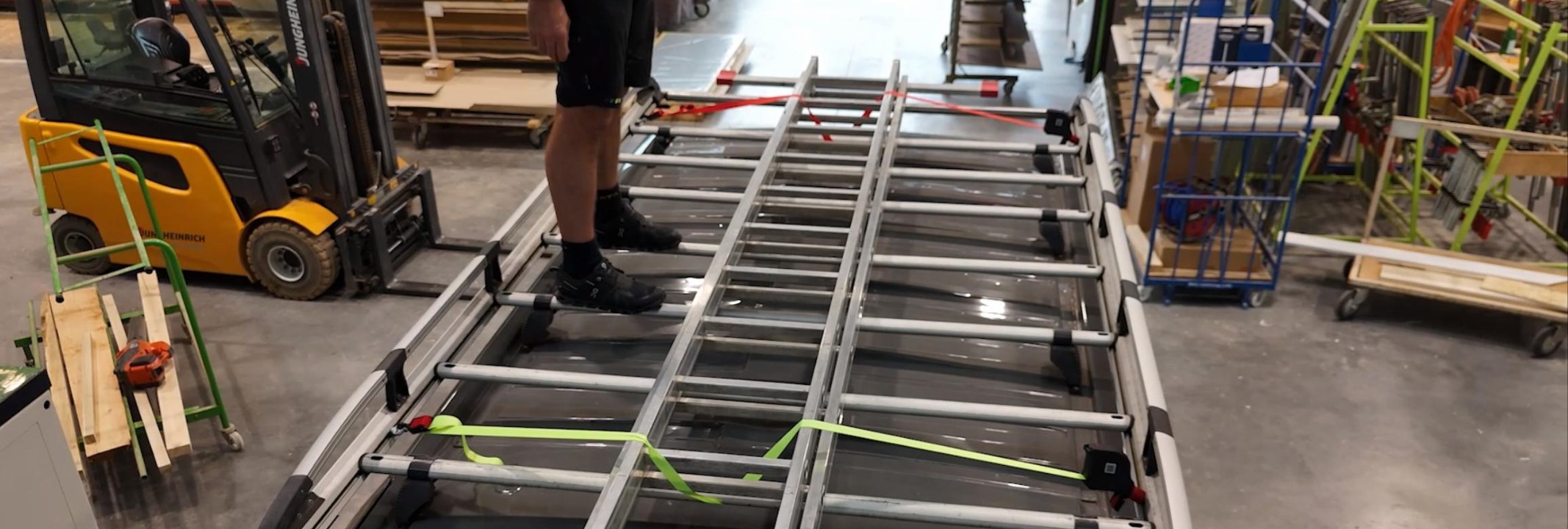 Eine Leiter auf dem Dachträger eines Transporters, gesichert mit FIXOMETER